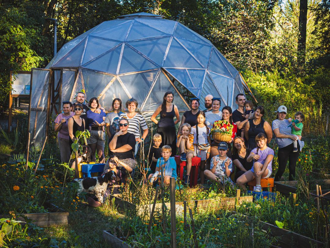 Ogrodnicy ze szklarnią kopułową w tle