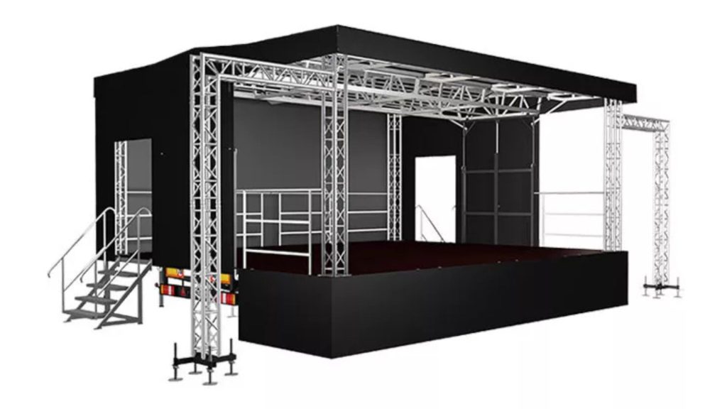 Mobilna scena plenerowa — wizualizacja 3D czarnej sceny estradowej na przyczepie. Podwyższony podest sceniczny z czarnym wykończeniem, nad którym rozpięta jest aluminiowa konstrukcja kratownicowa (truss) podtrzymująca zadaszenie. Z lewej strony schody z poręczą umożliwiające wejście na scenę. Z tyłu czarne ściany kulis z przestrzenią dla techniki oraz miejscem na ekran lub backdrop. Po prawej stronie dodatkowa wolnostojąca wieża kratownicowa na oświetlenie. Konstrukcja opiera się na regulowanych stopach poziomujących.
